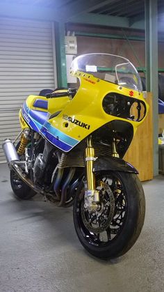 a yellow and blue motorcycle parked in a garage