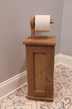 a wooden toilet paper dispenser on the floor