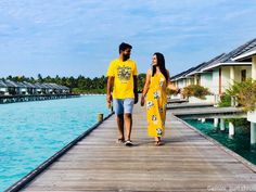 a man and woman walking along a pier