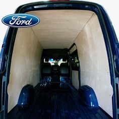 the back end of a blue ford truck with its cargo door open and luggage in it