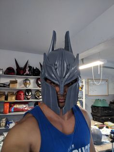 a man in a blue tank top wearing a metal mask