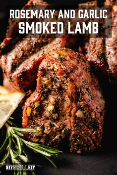 rosemary and garlic smoked lamb on a black plate with lemon wedges next to it