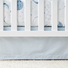 a baby crib with blue and white bedding