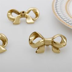 three pieces of gold metal with bows on them