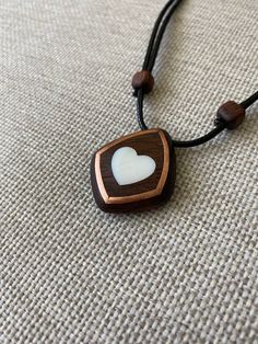 Size: 3.5 x 3 cm Immerse yourself in a world of romance with our elegant mahogany heart pendant with mother-of-pearl inlays. Every detail of this unique decoration embodies warmth and tenderness, creating a unique atmosphere. Our artisans carefully craft the pendant by hand, using only the finest materials. Mahogany adds natural warmth and sophistication, reproducing its unique patterns and textures. Mother-of-pearl inserts give the product a magical shine and a gentle glow that attracts attenti Handmade Mahogany Jewelry Gift, Handmade Mahogany Jewelry For Gift, Mahogany Handmade Jewelry For Gift, Handmade Mahogany Necklace For Gift, Unique Mahogany Jewelry For Gift, Unique White Heart-shaped Necklace, Valentine's Day Brown Heart Charm Jewelry, Mother Of Pearl Heart Pendant Jewelry Gift, Heart-shaped Brown Necklace For Gift