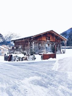 an old log cabin sits in the snow