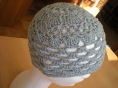 a crocheted hat sitting on top of a white mannequin's head