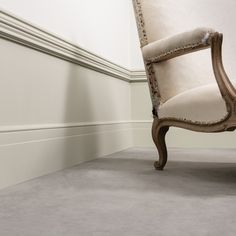 an old chair sitting in the corner of a room with white walls and flooring