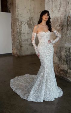 a woman in a wedding dress posing for the camera with her hands on her hips