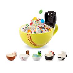 a yellow bowl filled with lots of different types of desserts next to bowls and spoons