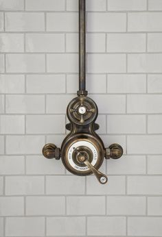 a wall mounted clock on the side of a white brick wall