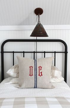 a bed with a black metal headboard and a white checkered bedspread