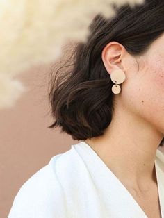 a close up of a person wearing some kind of earring on her left ear