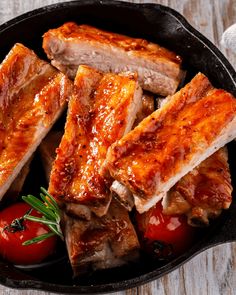 two pieces of meat sitting on top of a pan covered in ketchup and sauce