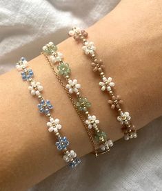 More details: - made out of white, golden, pastel green, blue and brown beads - threaded on nylon - closed with lobster clasps, jump rings 4mm, crimp ends and crimp covers made out of gold plated sterling silver - available in six sizes: 15cm, 16cm, 17cm,  18cm, 20cm and 22cm How to take care: - the material is durable so you can leave it on in water without hesitation Follow my Instagram @florescerjewelry to see some more products and how I make them!  Thanks for your order! Pastel Green Accessories, Green Flower Bracelet, Bohemian Gold Beaded Bracelet With Flower Charm, Green Beaded Jewelry, How To Make Flower Bead Bracelet, Flower Beads Bracelet, Pretty Jewelry Necklaces, Preppy Jewelry, Bracelet Flower