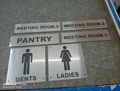 four signs on the floor indicating men's and women's restrooms