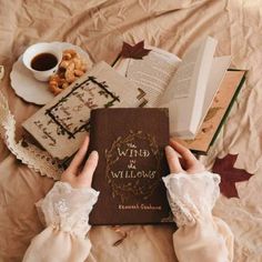 a person is reading a book on a bed with books and coffee in the background