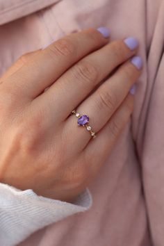 The Ophelia ring carries a certain romantic and gentle vibe - perfect for those who are looking for something strikingly beautiful yet delicate enough to wear every day. Details: Center stone Gemstone: Amethyst Stone Shape: Oval Measurements: approx. 5x7mm Total carat weight: 0.65 ct Side stones Gemstone: Moissanite Shape: Round Measurements: approx. 2mm Band measurements: approx. 1.8mm wide, approx. 1.5mm thick Pictured in vermeil, available also in sterling silver or rose gold vermeil. Also available in solid gold. Contact us for pricing. The Ophelia ring is available in other gemstones as well. Purple Wedding Rings, Purple Stone Rings, Amethyst Ring Engagement, Amethyst Gold, Rose Quartz Ring, Purple Band, Amethyst Jewelry, Agate Ring, Purple Stones