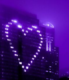 a very tall building with lots of windows in the city at night, lit up by bright lights