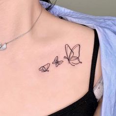 a woman's chest with three butterflies tattoo on her left side ribcage