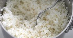 rice is being cooked in a pot with a ladle