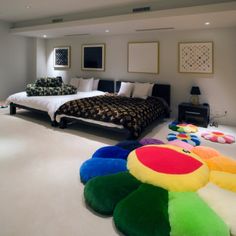 a large bedroom with two beds and colorful rugs on the floor next to each other