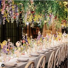 a long table is set with flowers and candles for an elegant wedding reception at the mansion