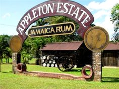 the sign for jamaica rum is in front of an old building with barrels under it