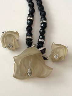 "Beautiful designer jewelry set from the late 70s/early 80s signed DVF for Diane Von Furstenberg. The set includes a beautiful beaded necklace made of faceted black glass beads called French Jet accented with clear rhinestone rondelles and a focal point of a frosted Lucite rose with rhinestone accents. The necklace measures 15\" long and ends in a spring ring clasp. The frosted Lucite rose measures 1.5\" by 1.5\" and is also accented with metal leaves, black enameled and set with clear rhineston Egyptian Earrings, Beautiful Beaded Necklaces, Vintage Jewelry Antique, Lucite Jewelry, Liquid Silver, Jewelry Antique, Metal Leaves, Amber Jewelry, Lampwork Glass Beads