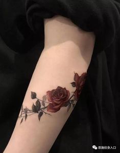 a woman's arm with roses on it and leaves in the middle of her arm