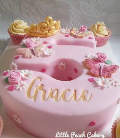 a pink cake with flowers and butterflies on it