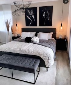 a bedroom with two paintings above the bed