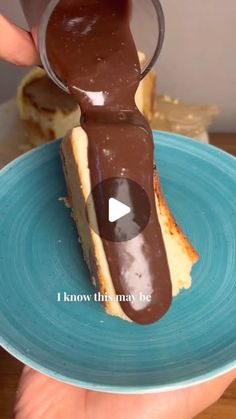 someone is pouring chocolate on top of a peanut butter and jelly baguette in a blue plate