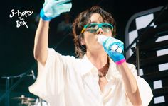 a man in white shirt and blue gloves on stage