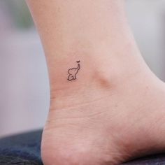 an elephant tattoo on the foot of a woman's left ankle is shown in black ink