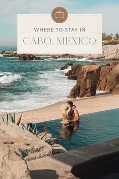 a man sitting in the middle of a pool next to the ocean with a sign that says where to stay in cabo, mexico