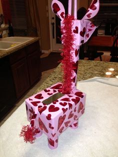 a pink box with hearts on it sitting on top of a counter next to a sink