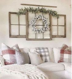 a living room filled with furniture and pillows on top of a white couch next to a window