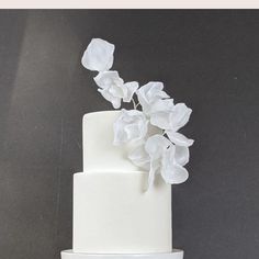 there is a white cake with flowers on the top and words above it that read, what's paper?