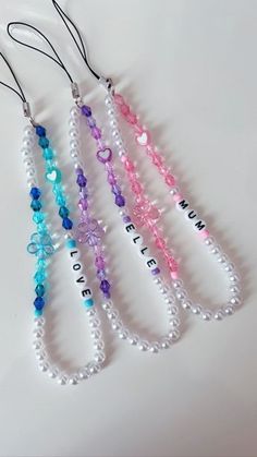 four necklaces with different colored beads hanging from them