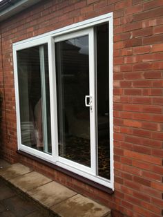 an image of a brick house with double doors on the outside and one window open