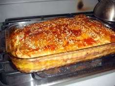 a casserole dish sitting on top of an oven with some food in it