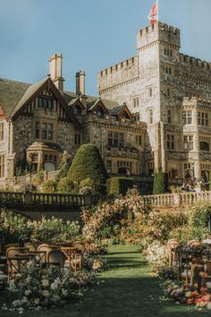 an old castle like building with lots of flowers around it