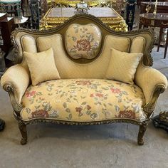 an old fashioned couch is sitting in a room with other antique furniture and antiques on the floor