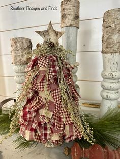 a red and white christmas tree with greenery in the shape of a star on top