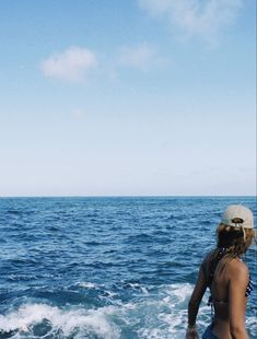 a woman standing on top of a boat in the ocean