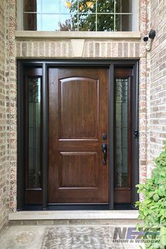 a wooden door with glass on the side of a brick building