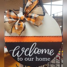 a welcome sign with a large bow on it's head and the words welcome to our home