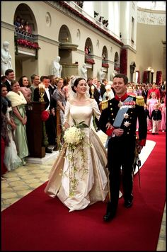 a bride and groom are walking down the aisle