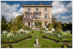 a large house with lots of flowers in the front yard